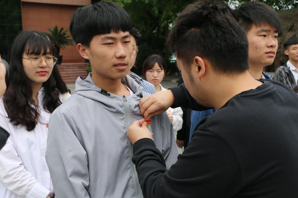 白锐老师为新入团团员佩戴团徽